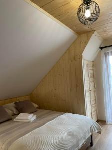a bedroom with a bed in a room with wooden walls at Apartament 4 os u Króla in Biały Dunajec