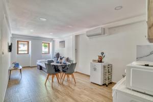 cocina y sala de estar con mesa y sillas en Apartments Pavic, en Risan