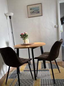 een tafel met twee stoelen en een tafel met een plant erop bij Adorable 1 bedroom guesthouse in Burford