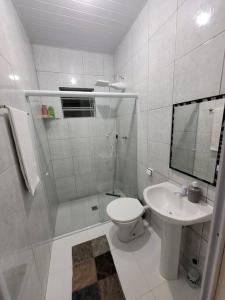 a white bathroom with a toilet and a sink at Lugarzin1 - Privado e Aconchegante in Vitória da Conquista