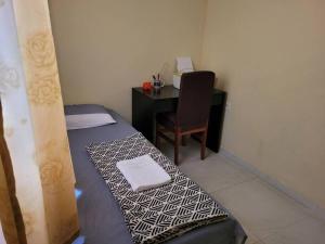 a room with a bed and a desk with a chair at Lugarzin1 - Privado e Aconchegante in Vitória da Conquista