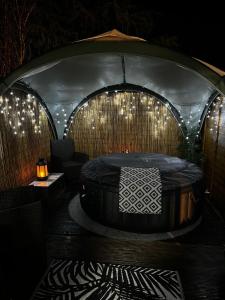 een kamer met een hot tub in een tent met verlichting bij Adorable 1 bedroom guesthouse in Burford
