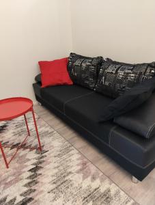 - un canapé noir avec un oreiller et une chaise rouges dans l'établissement Your loft, à Seinäjoki