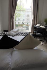 two beds in a room with a table and a window at 1 bedroom apartment - The Onyx in Cheltenham