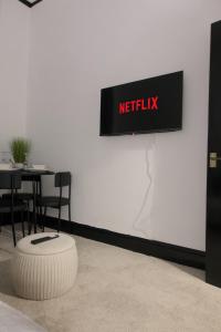 a sign that reads netflix on a wall with a table at 1 bedroom apartment - The Onyx in Cheltenham