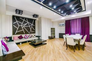 uma sala de estar com uma mesa e um sofá em Konsul Apartment Nizami em Baku