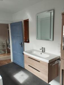 ein Badezimmer mit einem Waschbecken und einer blauen Tür in der Unterkunft Dani´s Feriendomizil in Wieda