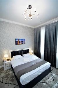 a bedroom with a large bed and a chandelier at Next Hotel Samarkand in Samarkand