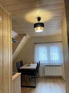a dining room with a table and a window at Apartament 4 os u Króla in Biały Dunajec