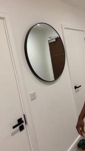uno specchio circolare sul muro di un bagno di TMW stays a Londra