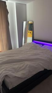 a bedroom with a bed with a purple light at TMW stays in London