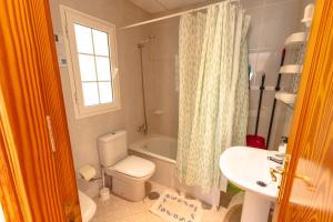 a bathroom with a toilet and a tub and a sink at Apartamento junto el mar in Gran Tarajal +50 photos