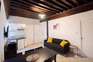 un soggiorno con un divano e un tavolo di Résidence Le Zola composé de 3 appartements distincts en Hyper Centre de Dijon avec WIFI a Digione