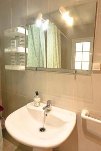 a bathroom with a white sink and a mirror at Apartamento junto el mar in Gran Tarajal