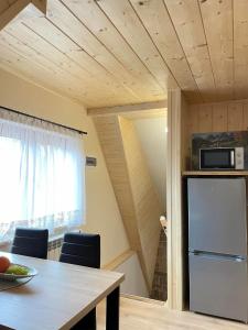 a kitchen with a table and a refrigerator in a room at Apartament 4 os u Króla in Biały Dunajec