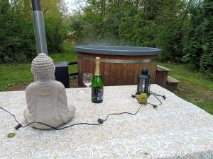 uma estátua de um Buda e uma garrafa de vinho em Buitenplaats de Oorsprong em Brouwershaven