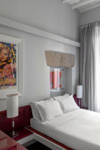 a bedroom with a large white bed and two lamps at BDB Rooms Margutta in Rome