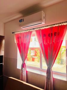 okno z czerwonymi zasłonami przed oknem w obiekcie Casa BB&Djassi w mieście Ponta do Sol