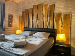 ザンクト・アンドレーアスベルクにあるBlockhaus Kik im Harzのベッドルーム1室(ランプ2つ、木製の壁付)
