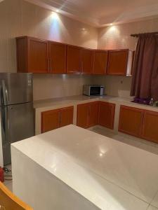 a kitchen with wooden cabinets and a white counter top at APPHIA SERVICES in Pointe-Noire