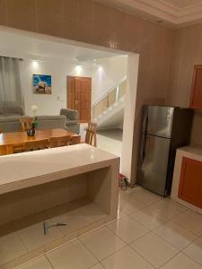 APPHIA SERVICES في بوانت نوار: مطبخ وغرفة معيشة مع طاولة وثلاجة