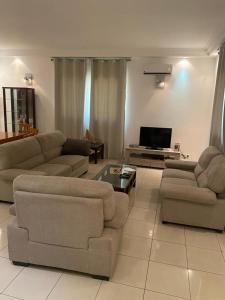 a living room with two couches and a tv at APPHIA SERVICES in Pointe-Noire