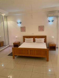 APPHIA SERVICES في بوانت نوار: غرفة نوم بسرير خشبي مع مواقف ليلتين