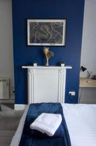 a bedroom with a blue wall and a bed with towels at Studio apartment - The Sapphire 