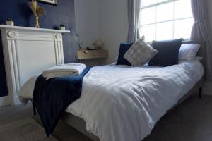 a bed with blue and white sheets and pillows at Studio apartment - The Sapphire 
