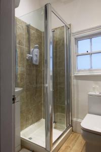 a shower with a glass door in a bathroom at Studio apartment - The Sapphire 