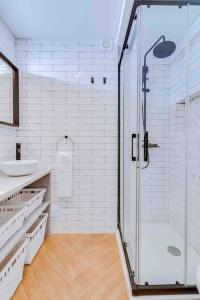 een witte badkamer met een douche en een wastafel bij Downtown Bingo Apartment in Faro