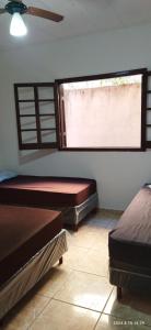 1 Schlafzimmer mit 2 Betten und einem Fenster in der Unterkunft Casa das orquídeas in Santana do Riacho