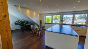 a kitchen and dining room with a blue counter top at MaMi Apartments - Cloud 9 in Pliezhausen
