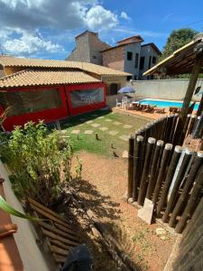 einen Hinterhof mit einem Zaun und einem Pool in der Unterkunft Casa das orquídeas in Santana do Riacho