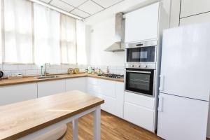 a kitchen with white cabinets and a white refrigerator at LOFT 55 Domu de tunì in Ancona