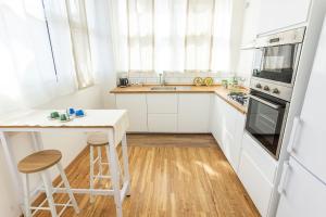 a white kitchen with a table and a stove top oven at LOFT 55 Domu de tunì in Ancona