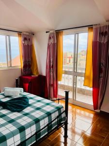 um quarto com uma cama e uma grande janela em Casa BB&Djassi em Ponta do Sol