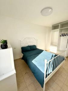 Qiryat YamにあるSea Breeze Apartmentのベッドルーム1室(青い掛け布団付きのベッド1台付)