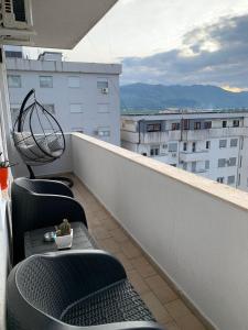 een balkon met stoelen en uitzicht op een gebouw bij Ridi's Comfort Apartment 2 in Shkodër