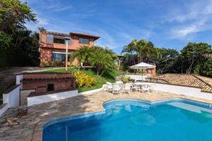 una casa con piscina frente a una casa en Mansão Luxury Alto da Brava, en Búzios