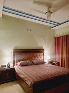 a bedroom with a bed and two night stands with lamps at Dream home 2 & 4 bedroom Family house in Karachi