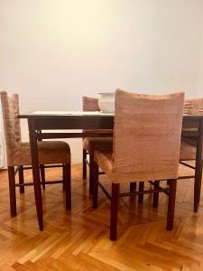 a dining room table with chairs and a table with dishes on it at City Apartment Gevgelija in Gevgelija