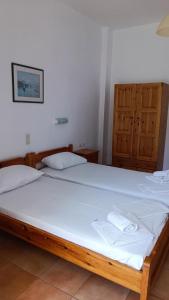 a bedroom with two beds with white sheets at Bonisis Studios in Laganas