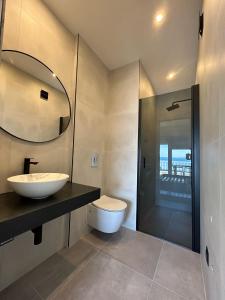 La salle de bains est pourvue d'un lavabo, de toilettes et d'un miroir. dans l'établissement Apartments Johnny, à Podstrana