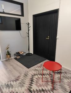 Cette chambre comprend une porte noire et une chaise rouge. dans l'établissement Your loft, à Seinäjoki