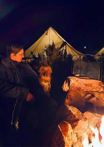 a man and a dog sitting next to a tent at Zion Glamping Adventures in Hildale