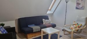 ein Wohnzimmer mit einem blauen Sofa und einem Stuhl in der Unterkunft Cottage with a view in Ölfus