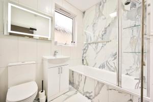 a bathroom with a toilet sink and a shower at Greenwich Holiday Home in London