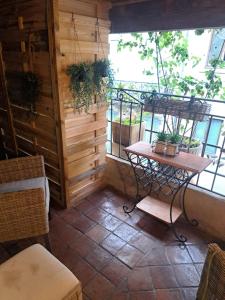 a small balcony with a table and a window at Hôtel Le Patio de Sophie in Sisteron