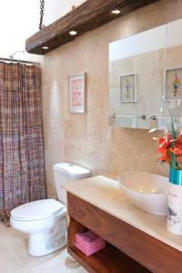 ein Badezimmer mit einem Waschbecken, einem WC und einem Spiegel in der Unterkunft Apartment in the clouds in Antigua Guatemala